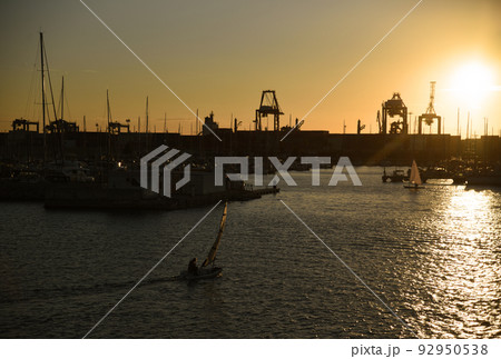 Sailboat on sunset in harbour. Sailing on sea on sailboat on the waves. Sailboat on sunset in harbour. Sailing on sea on sailboat on the waves. 92950538
