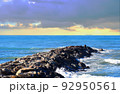 Breakwater with waves in sea. Waves at the stone pier. 92950561