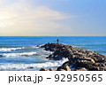 Fisherman on Masonry breakwater. A fisherman catches fish in the sea on a stone breakwater. 92950565