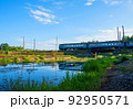 Train on bridge over river in wild. Passenger train passes over a railway bridge over a wild river 92950571