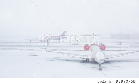 Snow covered commercial plane at the airport. Close-up of the plane after snowfall. Winter bad weather conditions. Snow covered commercial plane at the airport. Close-up of the plane after snowfall. Winter bad weather conditions. 92950759