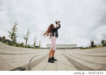 Young attractive woman biker wearing bike safety helmet while standing at empty stadium outdoors Young attractive woman biker wearing bike safety helmet while standing at empty stadium outdoors 92951654