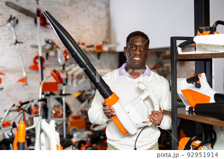 Ordinary man is buying new blower in tool store 92951914