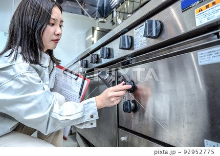 厨房を確認する若い女性　ガスオーブン 92952775
