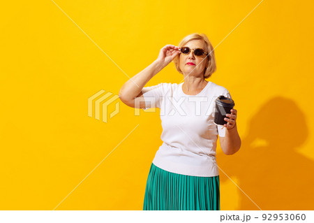 Studio shot of fashionable senior woman in summer style outfit isolated on bright yellow background. Concept of beauty, emotions, vacation, travel 92953060
