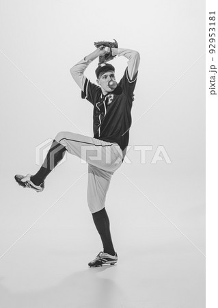 Portrait of young man, baseball player, pitcher with bubblegum playing, serving ball. Black and white photography. Active game Portrait of young man, baseball player, pitcher with bubblegum playing, serving ball. Black and white photography. Active game 92953181