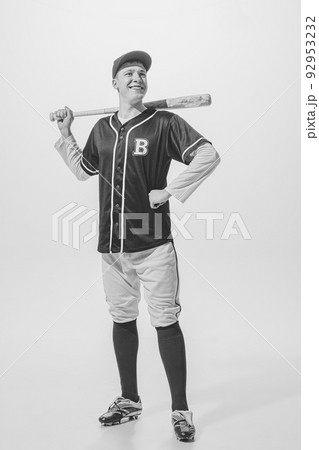 Portrait of cheerful young man, baseball player in uniform with bat posing. Black and white photography. Exhibition game Portrait of cheerful young man, baseball player in uniform with bat posing. Black and white photography. Exhibition game 92953232