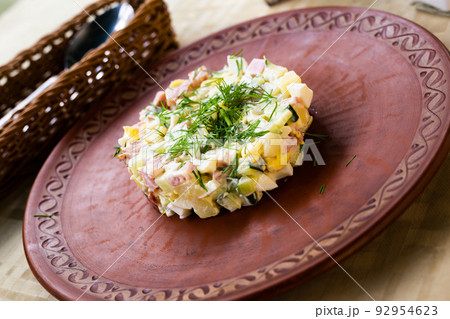 salad with peas and mayonnaise, served in a cylinder on a clay plate 92954623