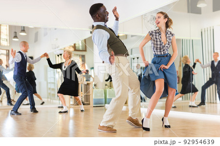 Woman with african man practising charleston dancing Woman with african man practising charleston dancing 92954639