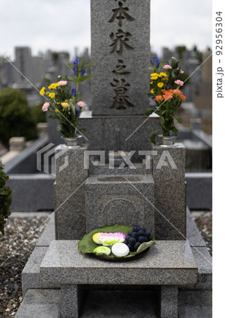 きれいなお花とお菓子とブドウがお供えしてあるお墓 きれいなお花とお菓子とブドウがお供えしてあるお墓 92956304