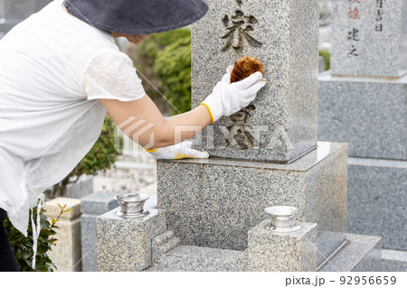 お墓参りに来てたわしでお墓の掃除をしている女性 お墓参りに来てたわしでお墓の掃除をしている女性 92956659