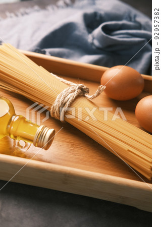 Yellow long spaghetti egg and oil on table  92957382