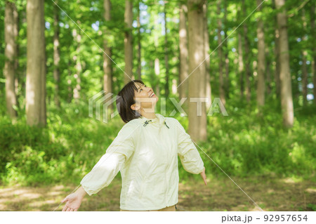 森林を散歩する若い女性 92957654