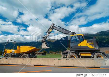 Yellow medium wheeled excavator with mini dumper Yellow medium wheeled excavator with mini dumper 92958633