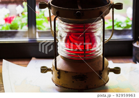 Red marine signal light stands on a windowsill, close up 92959963