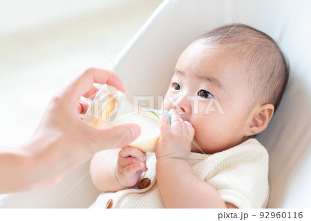 哺乳瓶に手を添える赤ちゃん 自分で持つ セルフ飲み 哺乳瓶に手を添える赤ちゃん 自分で持つ セルフ飲み 92960116