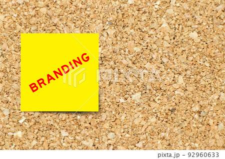 Yellow note paper with word branding on cork board background with copy space 92960633