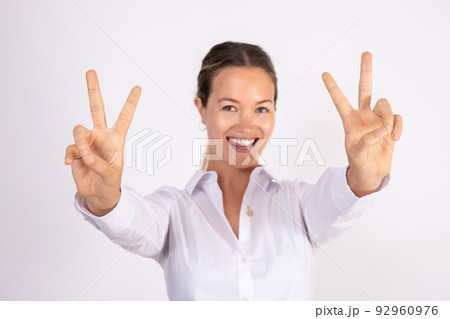 Portrait of successful young businesswoman making victory symbol Portrait of successful young businesswoman making victory symbol 92960976