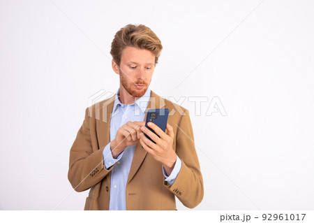 Portrait of serious businessman texting message on phone Portrait of serious businessman texting message on phone 92961017