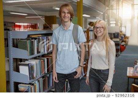 Portrait of two friends student standing in university library and looking camera 92962316