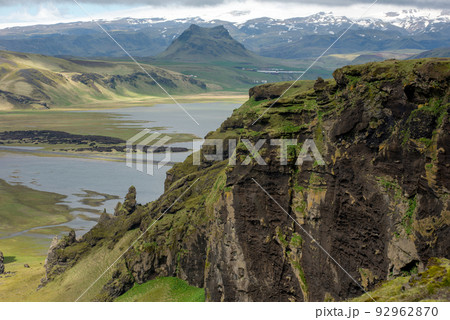 Icelandic landscape with volcanic lava ridge, glacier mountains, green grass. Vik area, Iceland 92962870