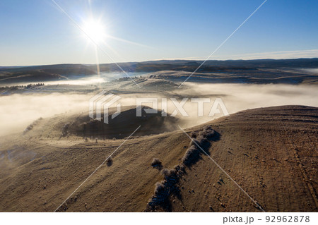 Flying over hills in mystic foggy winter morning. Aerial view Flying over hills in mystic foggy winter morning. Aerial view 92962878