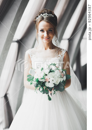 Portrait of stunning bride with long hair posing with great bouquet Portrait of stunning bride with long hair posing with great bouquet 92964387
