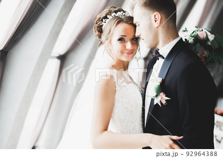 Perfect couple bride, groom posing and kissing in their wedding day Perfect couple bride, groom posing and kissing in their wedding day 92964388