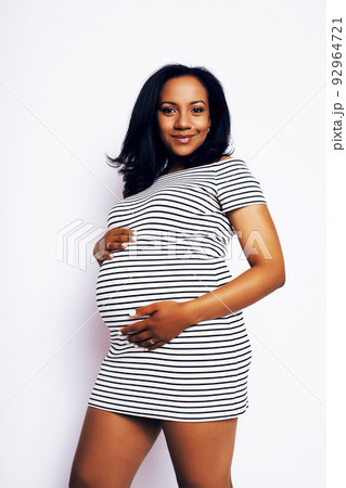 young pretty african american woman pregnant happy smiling, posing on white background isolated , lifestyle people concept copyspace close up 92964721