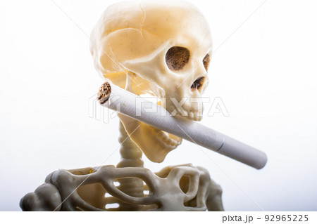 Skeleton figure pose smoking a cigarette. Smoking kills. Skeleton figure pose smoking a cigarette. Smoking kills. 92965225