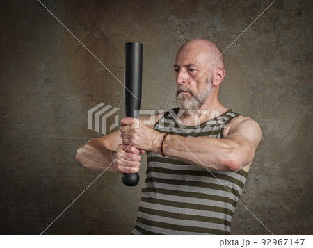 senior man is exercising with a steel club senior man is exercising with a steel club 92967147