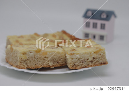 Cottage cheese casserole with raisins on a white plate. . On the background of the house. 92967314