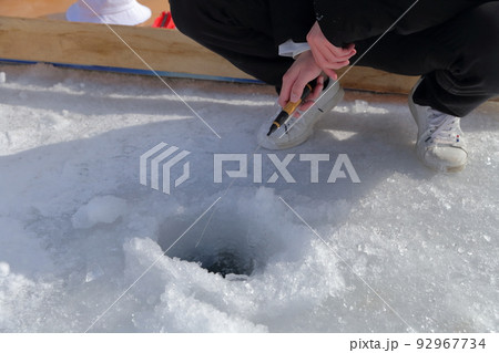 氷の穴に糸を垂らし当たりを待つ（ワカサギ釣り　松原湖　長野県 小海町） 92967734