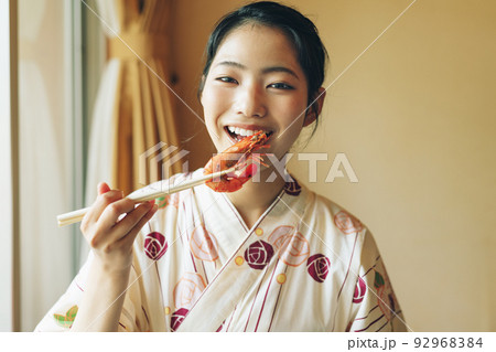 浴衣姿でエビを食べる女の子 92968384