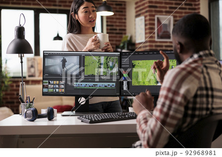 Creative couple making movie on editing software, creating professional video content on multimedia post production app. Working on film montage and footage with color grading effects. 92968981