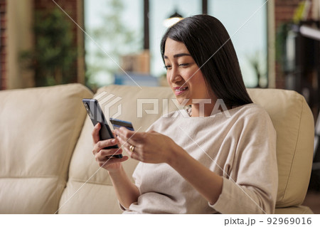 Asian woman buying online doing shopping using credit card on phone, smartphone credit happy female pay internet web purchase payment money customer asia app payment 92969016