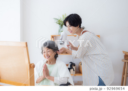 在宅介護イメージ　美容師さんに髪のお手入れをしてもらうシニア女性 92969654