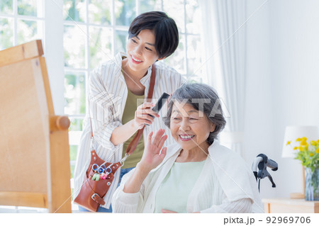 在宅介護イメージ　美容師さんに髪のお手入れをしてもらうシニア女性 92969706