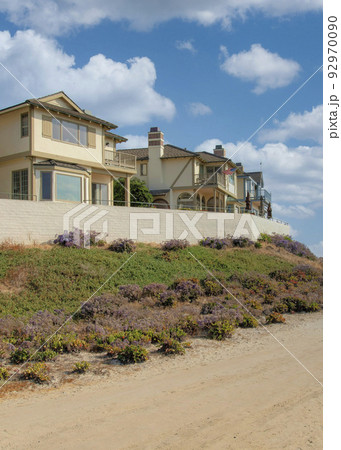 Vertical White puffy clouds Dirt road outside the fenced beach houses at Carlsbad, Californi Vertical White puffy clouds Dirt road outside the fenced beach houses at Carlsbad, Californi 92970090