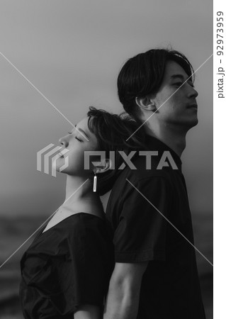 自然の中で背中合わせの男女 92973959