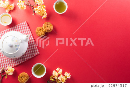 Chinese Mid-Autumn Festival concept made from mooncakes, tea and plum blossom. Chinese characters FU in the article refer to fortune good luck, wealth, money flow. 92974517