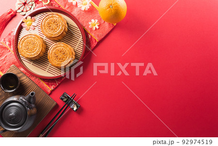 Chinese Mid-Autumn Festival concept made from mooncakes, tea and plum blossom. Chinese characters FU in the article refer to fortune good luck, wealth, money flow. 92974519