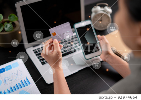 Close up shot of females hands holding credit card tand smart phone with technology icons. 92974664