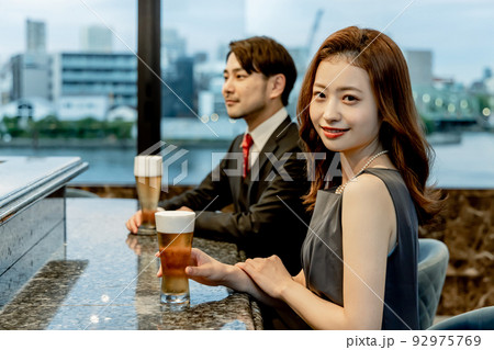 バーのカウンターでビールを飲むカップル 92975769