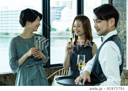 シャンパンを渡すウエイター 92975791
