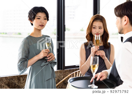 シャンパンを渡すウエイター 92975792
