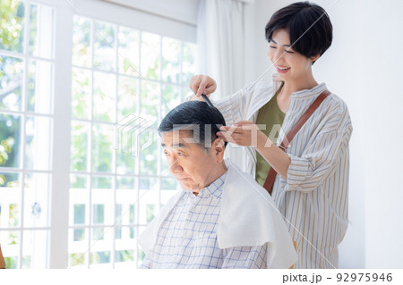 美容師さんに髪のお手入れをしてもらうシニア男性 92975946