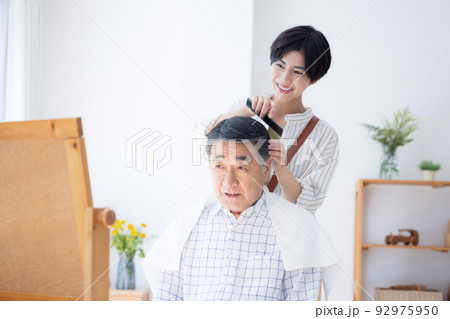 美容師さんに髪のお手入れをしてもらうシニア男性 92975950