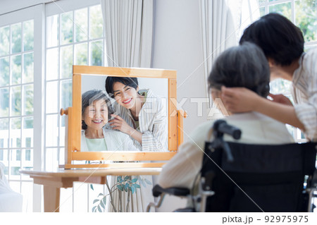 美容師さんに髪のお手入れをしてもらうシニア女性 92975975