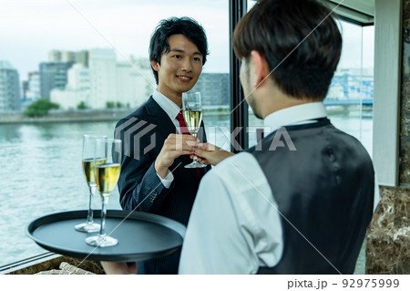 シャンパンを渡すウエイター シャンパンを渡すウエイター 92975999